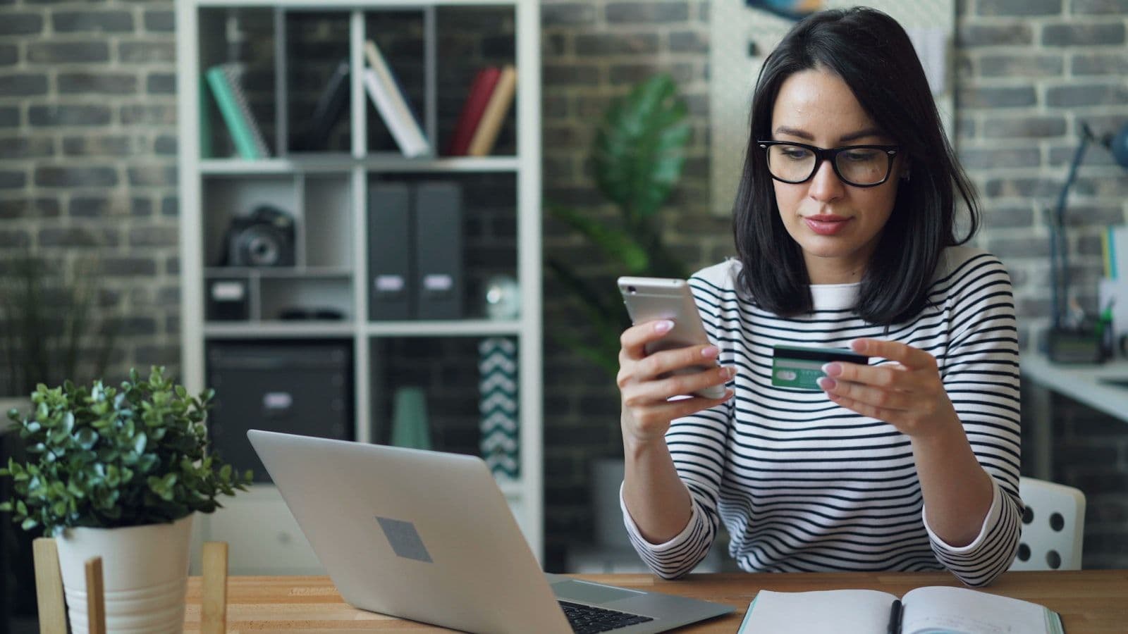Persona usa su tarjeta de crédito con el teléfono para construir crédito