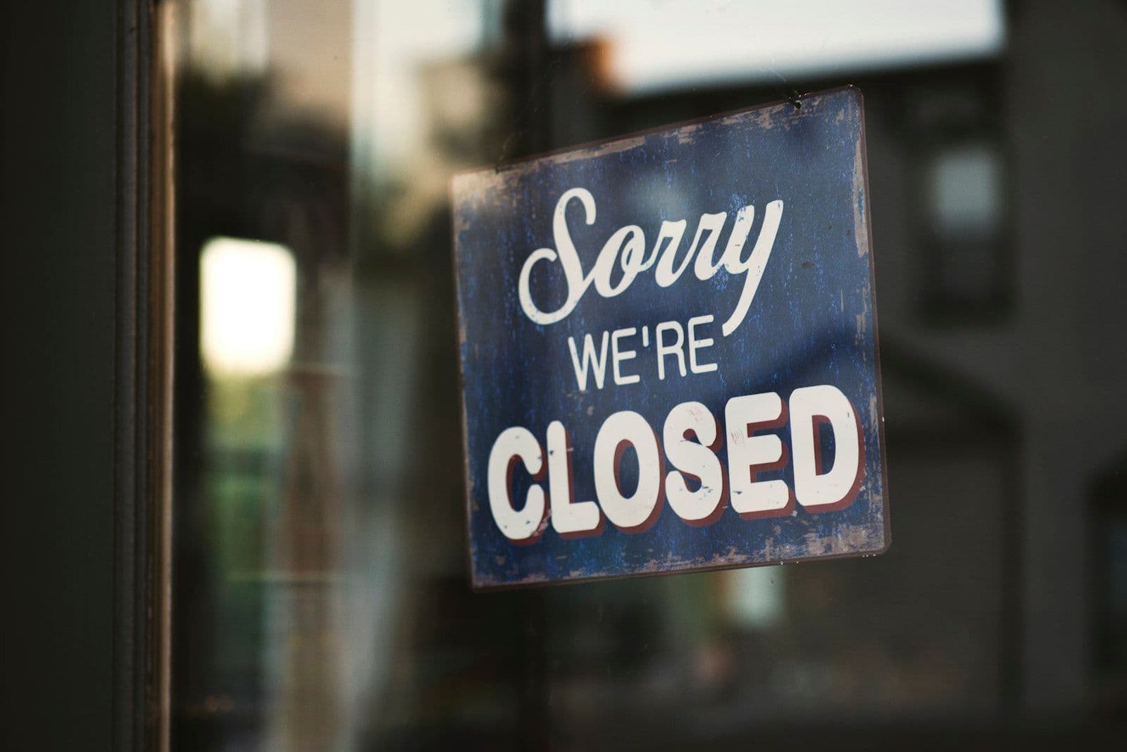 Closed sign on a door, illustrating why closed accounts remain on a credit report for years.