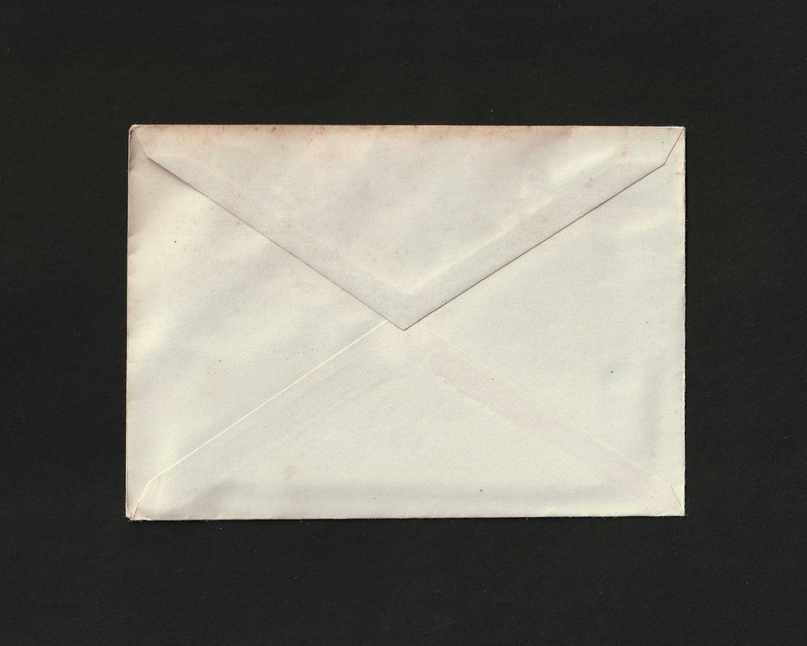 Sobre de correo abierto sobre un escritorio junto a una carta de cobro de deudas