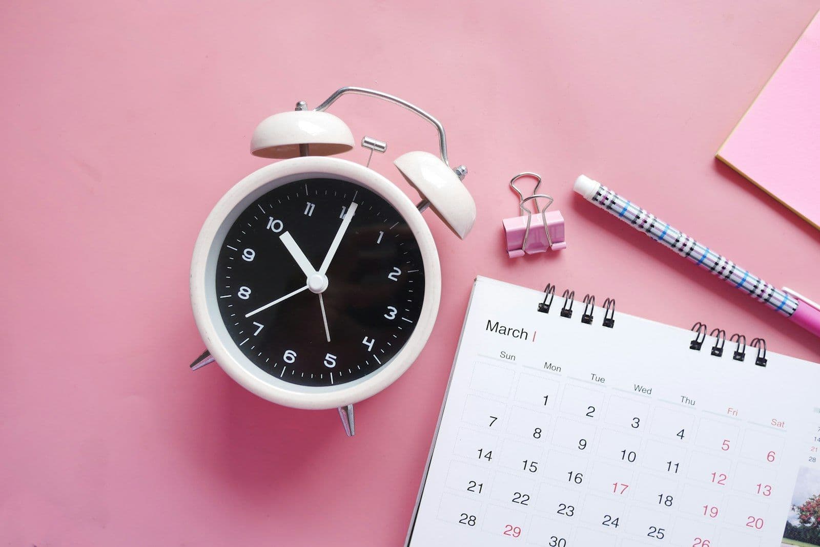 Un calendario y un reloj, ilustrando cuánto tiempo toma mejorar tu crédito.