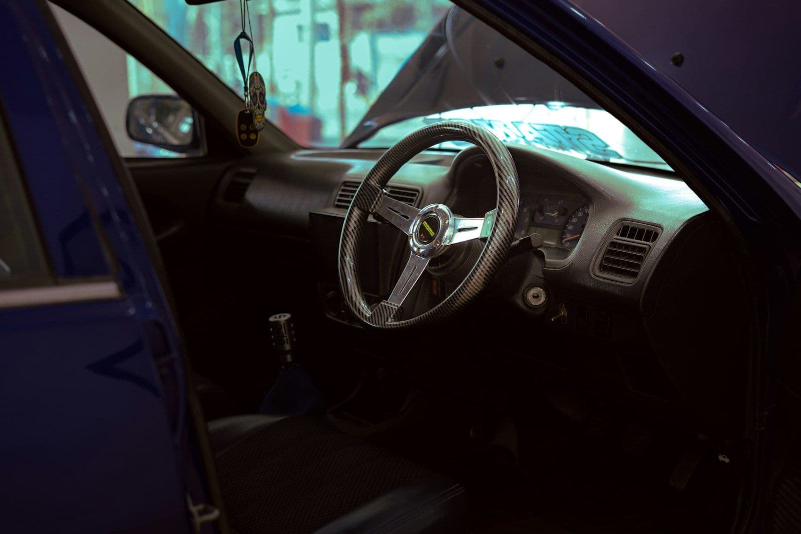 Interior of a blue car with aftermarket steering wheel, illustrating authorized User Credit Card Explained.