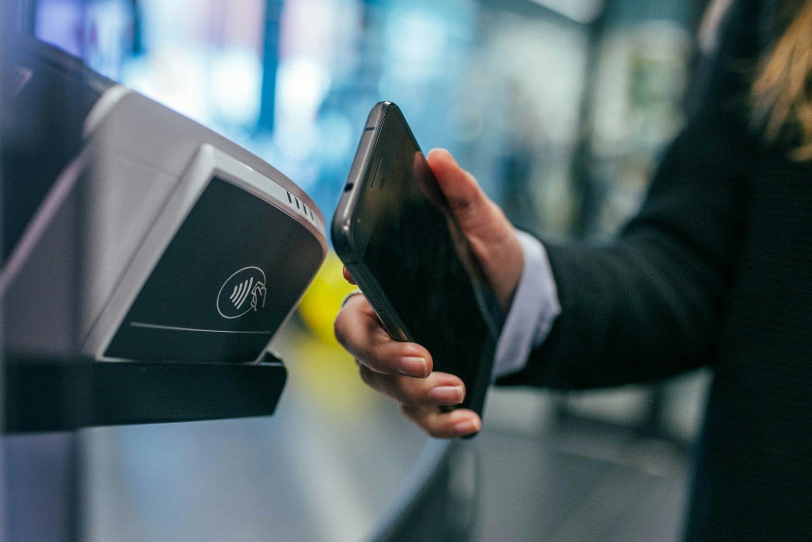 Phone tapping a payment terminal, illustrating buy now, pay later checkout and its credit effects.