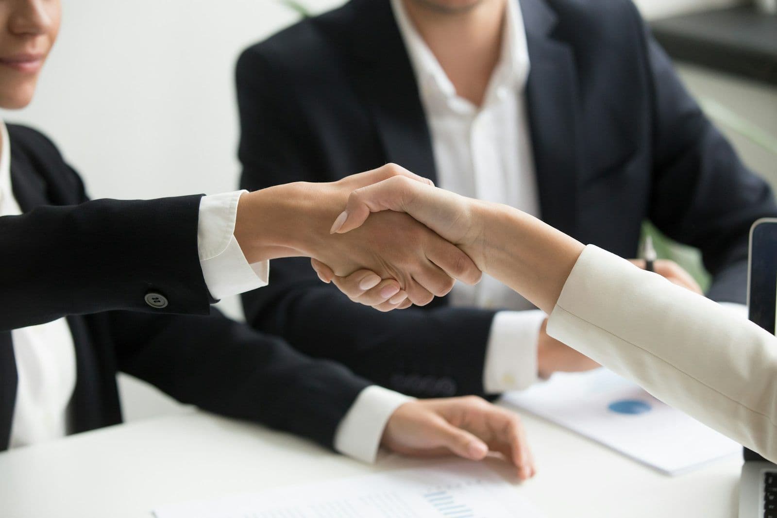 Two people shaking hands over a document, illustrating a pay-for-delete agreement with a collector.