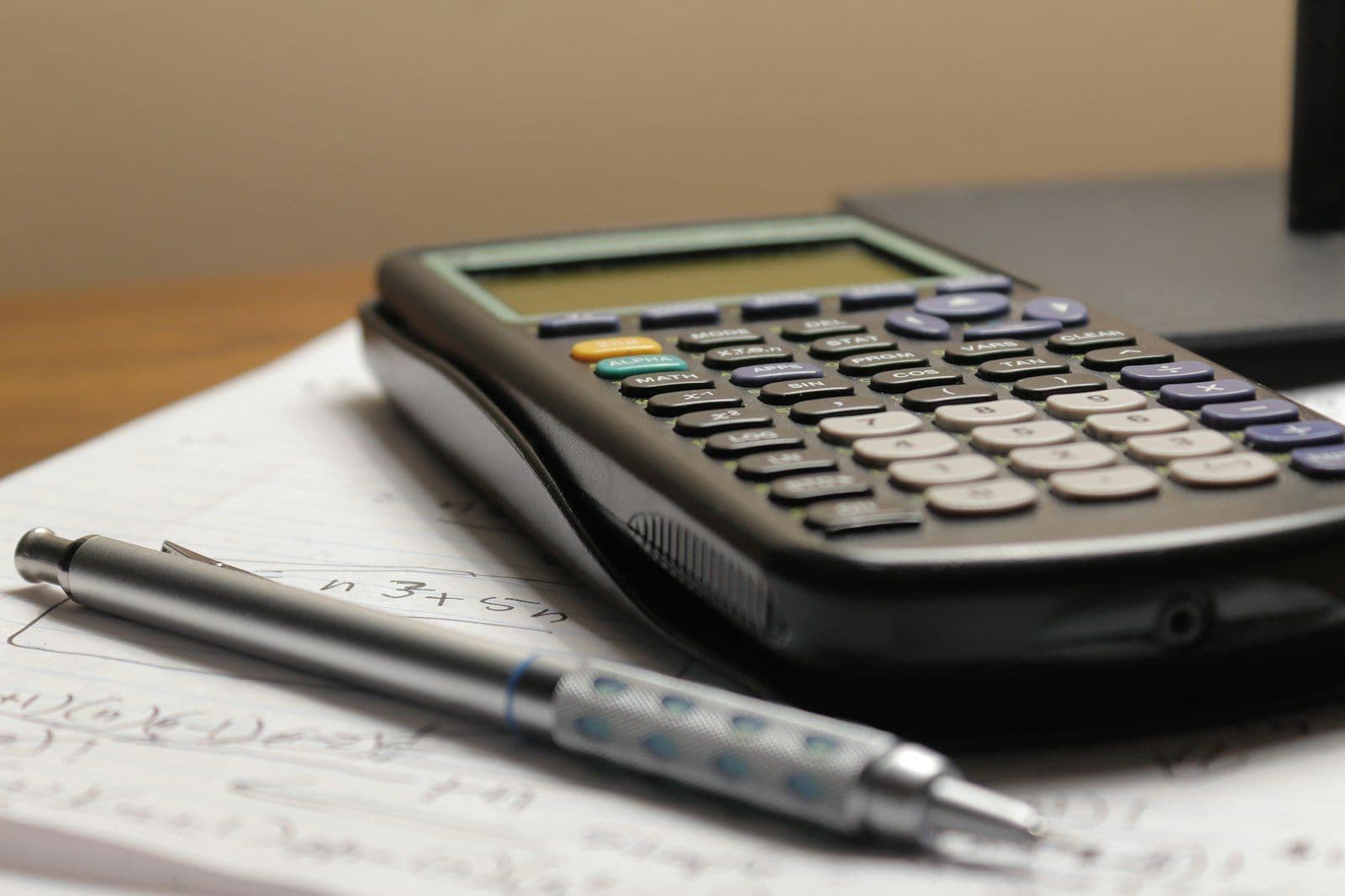 Calculator on financial paperwork, illustrating how credit card APR is calculated and charged.