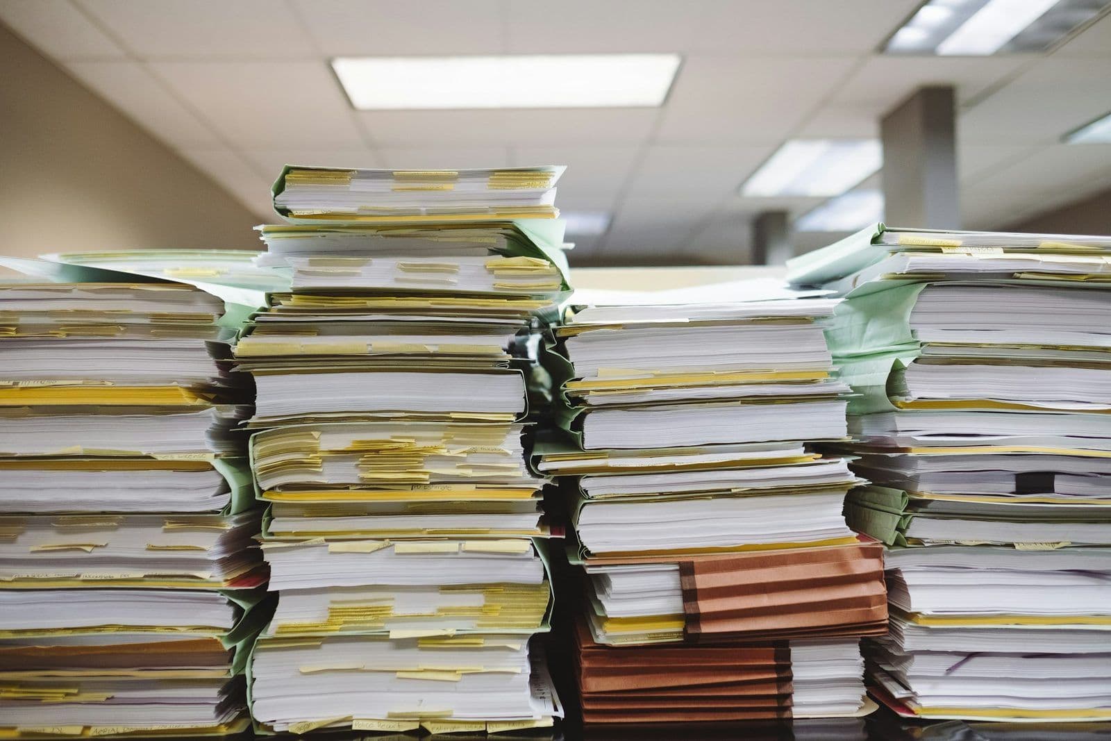 Documentos y carpetas apilados, ilustrando las compañías de liquidación de deudas.