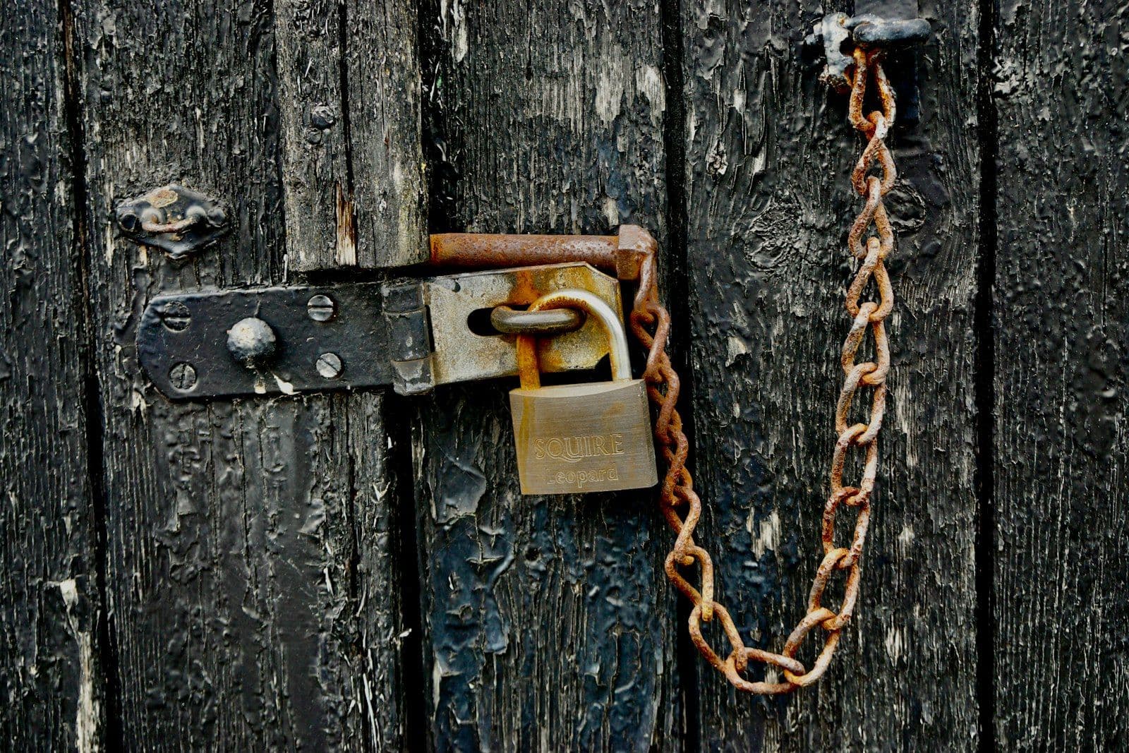 Brown padlock on black wooden door, illustrating extended Fraud Alert Under FCRA Section 605A.