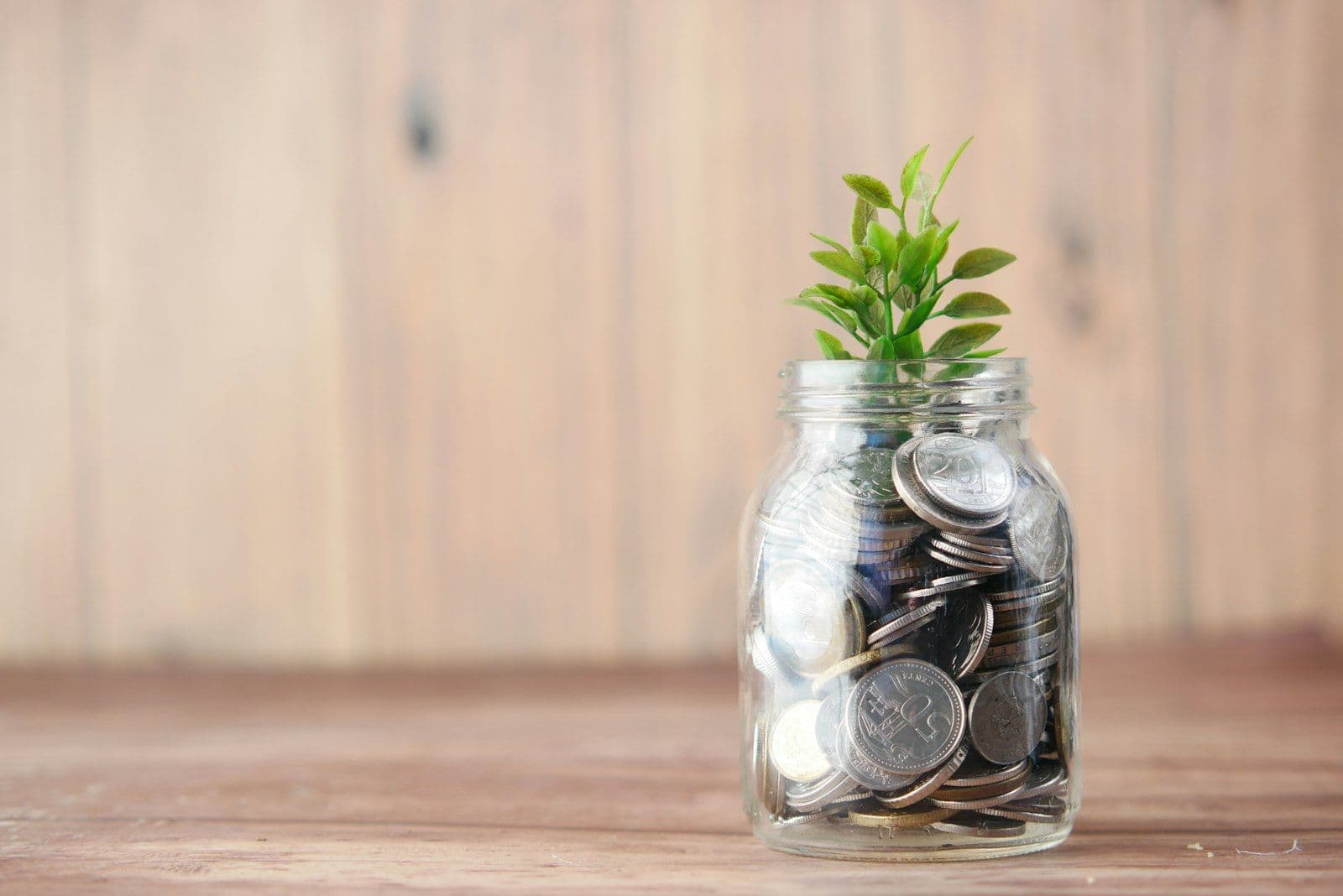 Frasco de ahorros con monedas que representa un préstamo para construir crédito