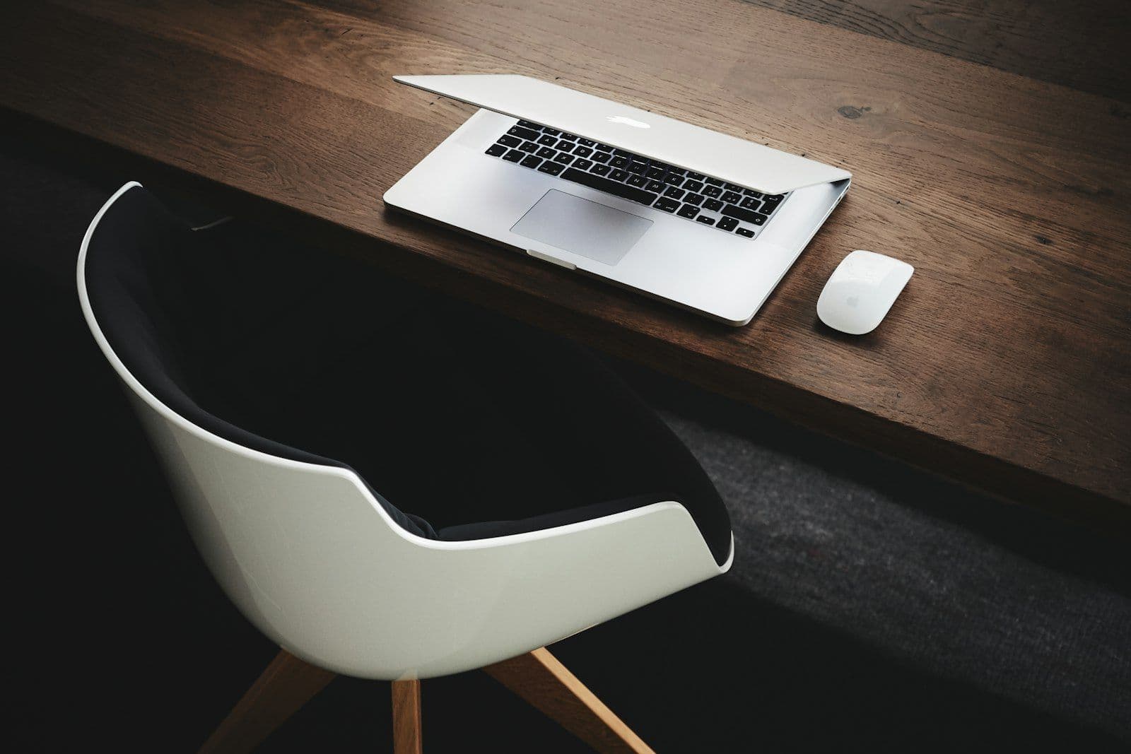 Apple MacBook beside computer mouse on table, illustrating how to Build Credit From Scratch.