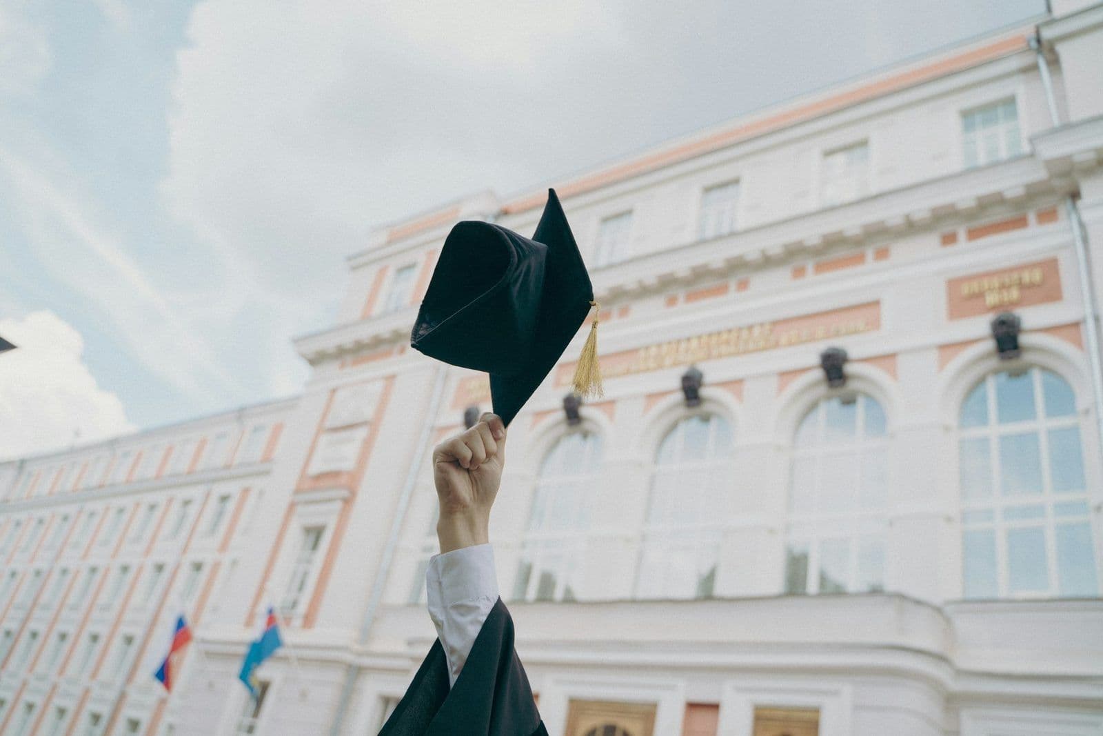 A graduation cap resting on a diploma, illustrating student loans on a credit report.