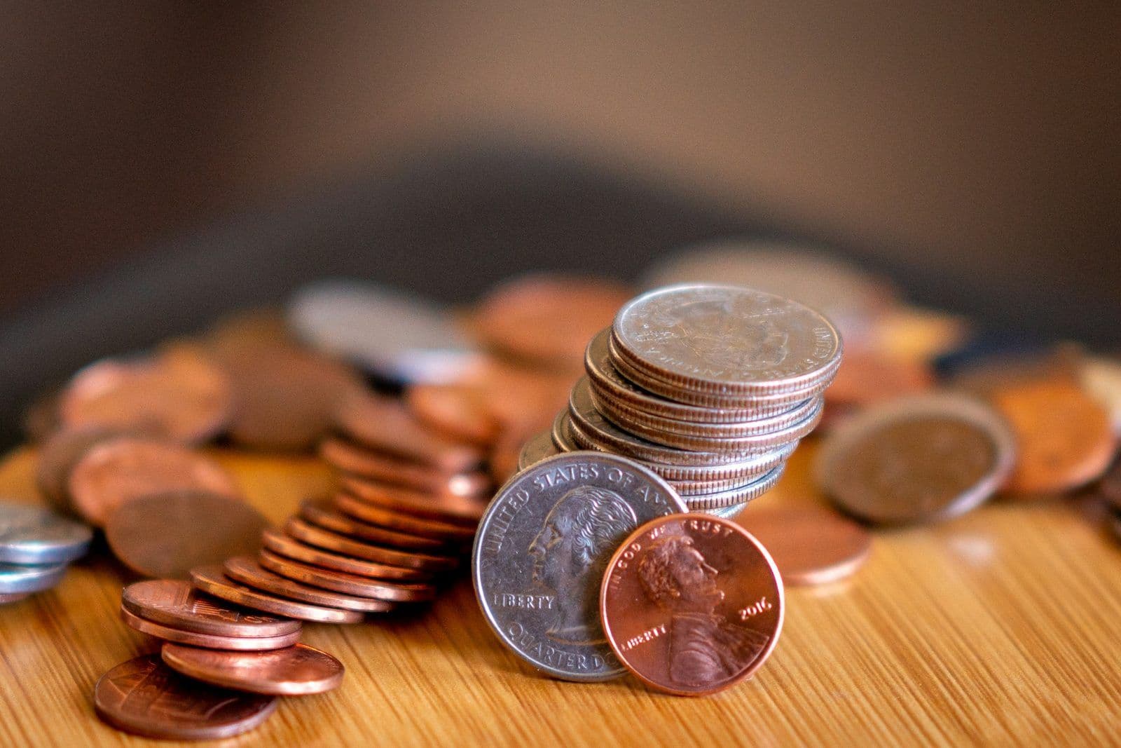 Monedas sobre una mesa de madera, ilustrando cómo funcionan las recompensas de cash back.
