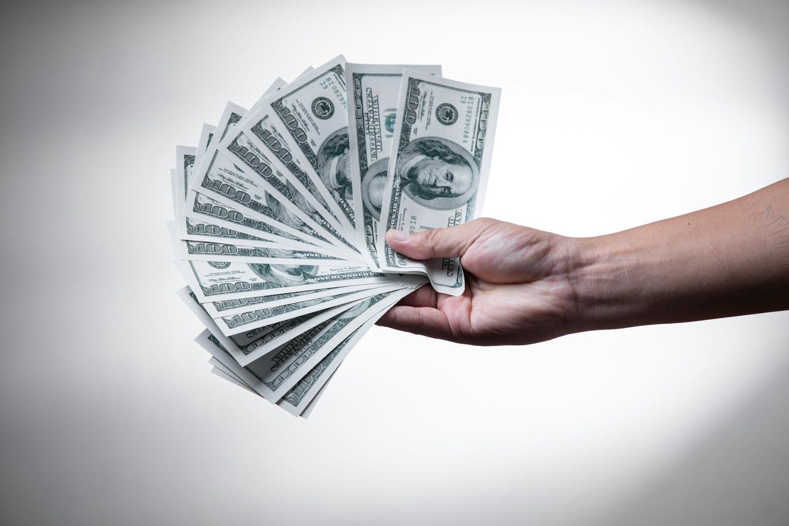 Counting dollar bills, illustrating that income never enters a credit score directly.