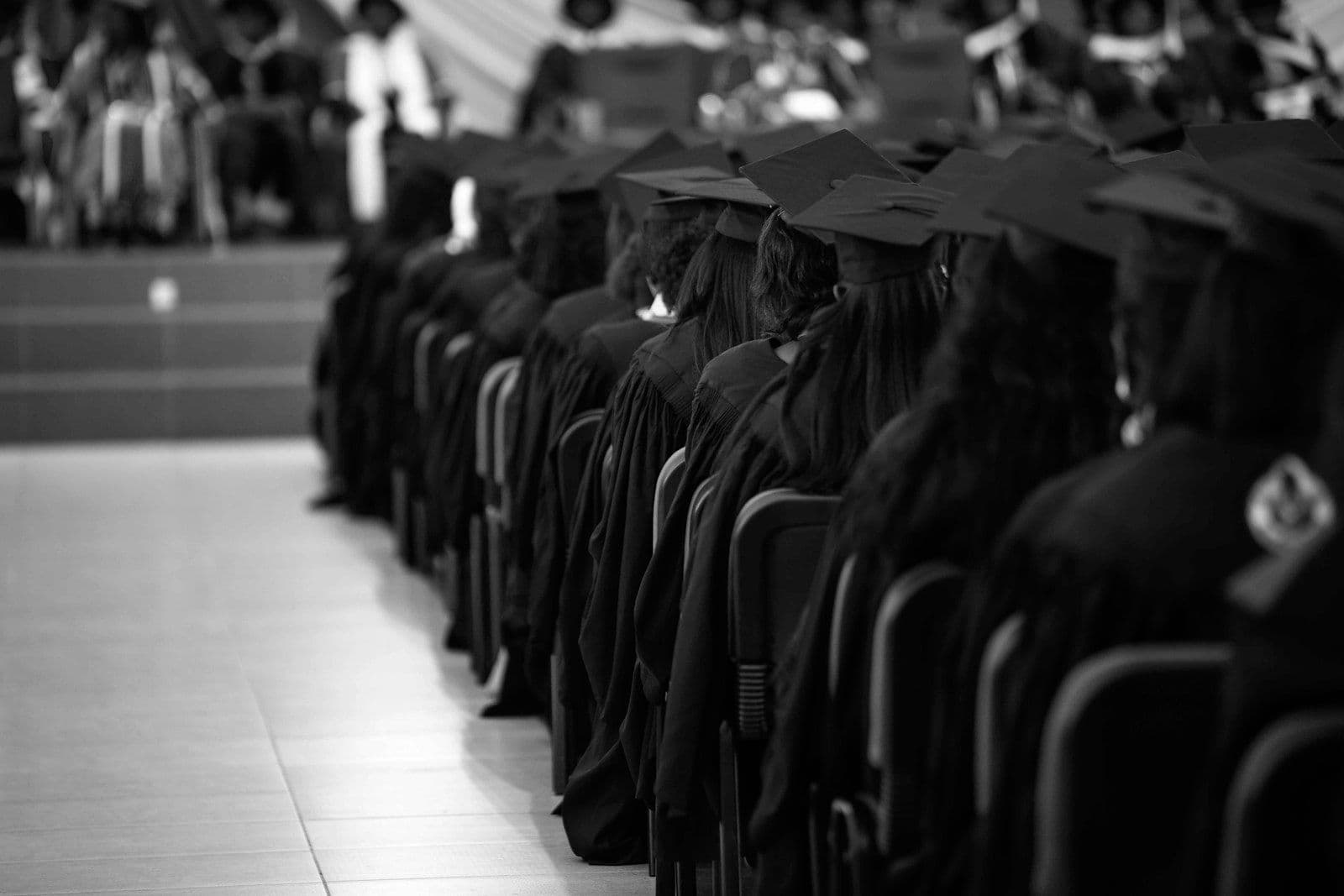 Rows of graduates in caps and gowns seated at a commencement ceremony