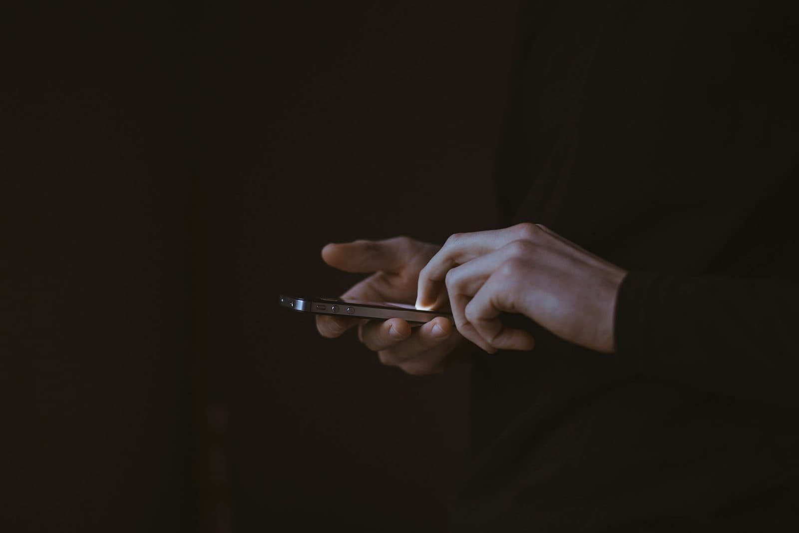 A hand holding a smartphone, illustrating credit repair apps and what to check before installing one.