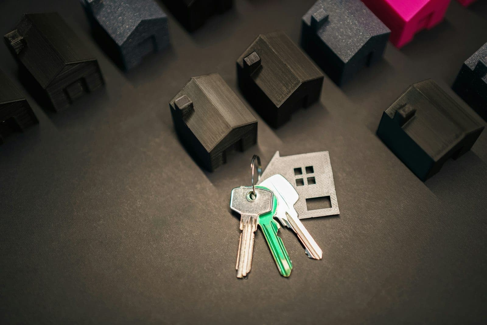 House keys beside small wooden model houses, illustrating which credit score mortgage lenders use.