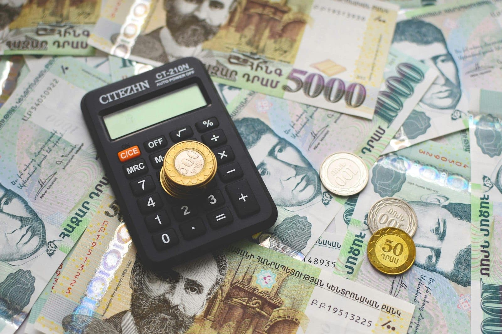 A calculator resting on cash, illustrating how lenders calculate debt-to-income ratio.