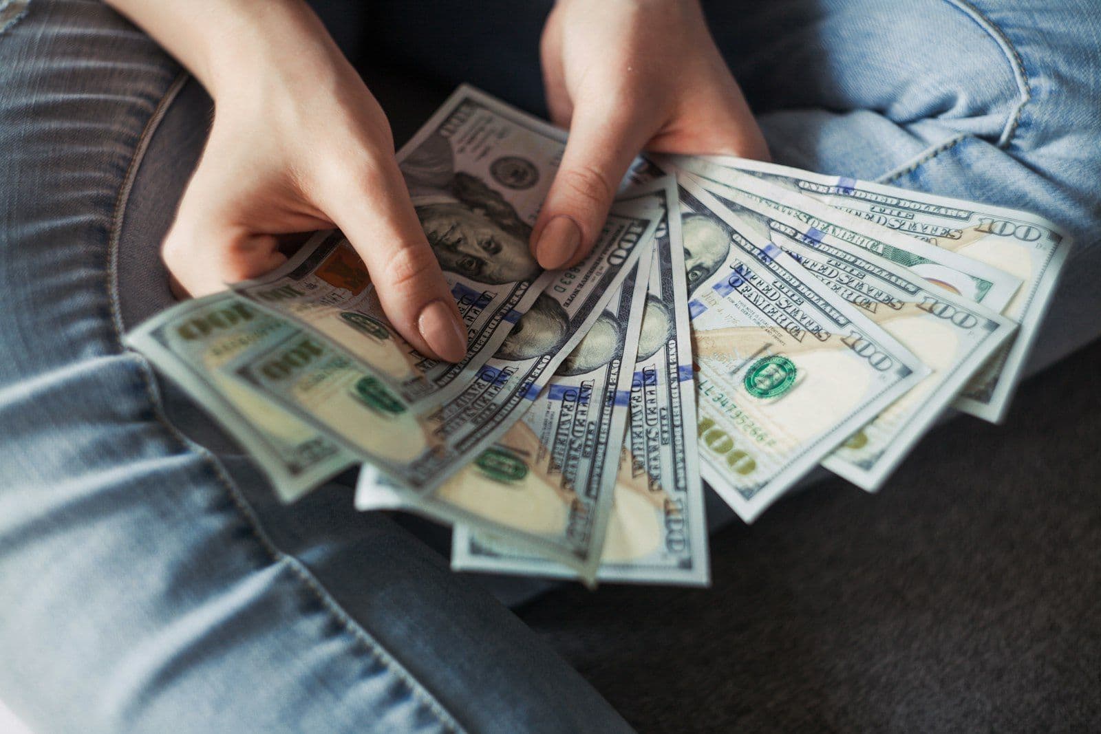 Counting cash dollar bills, illustrating payday loans and their effect on credit.