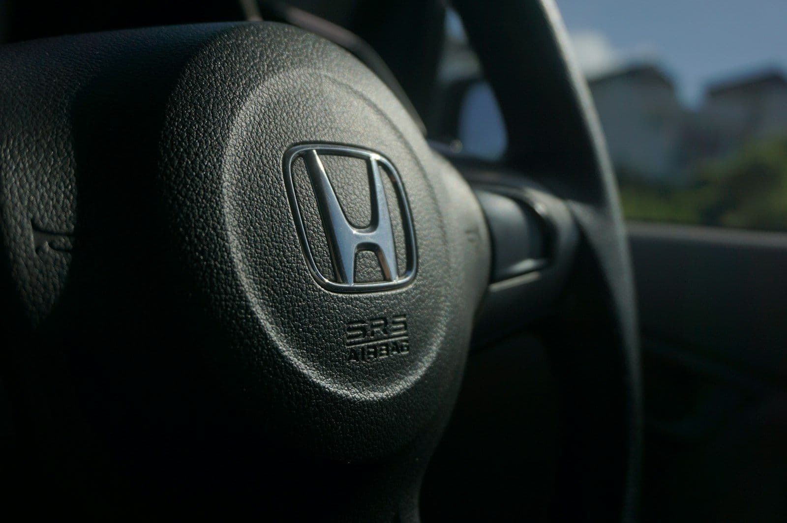 Close up of a car's steering wheel, illustrating FICO Auto Score Explained.