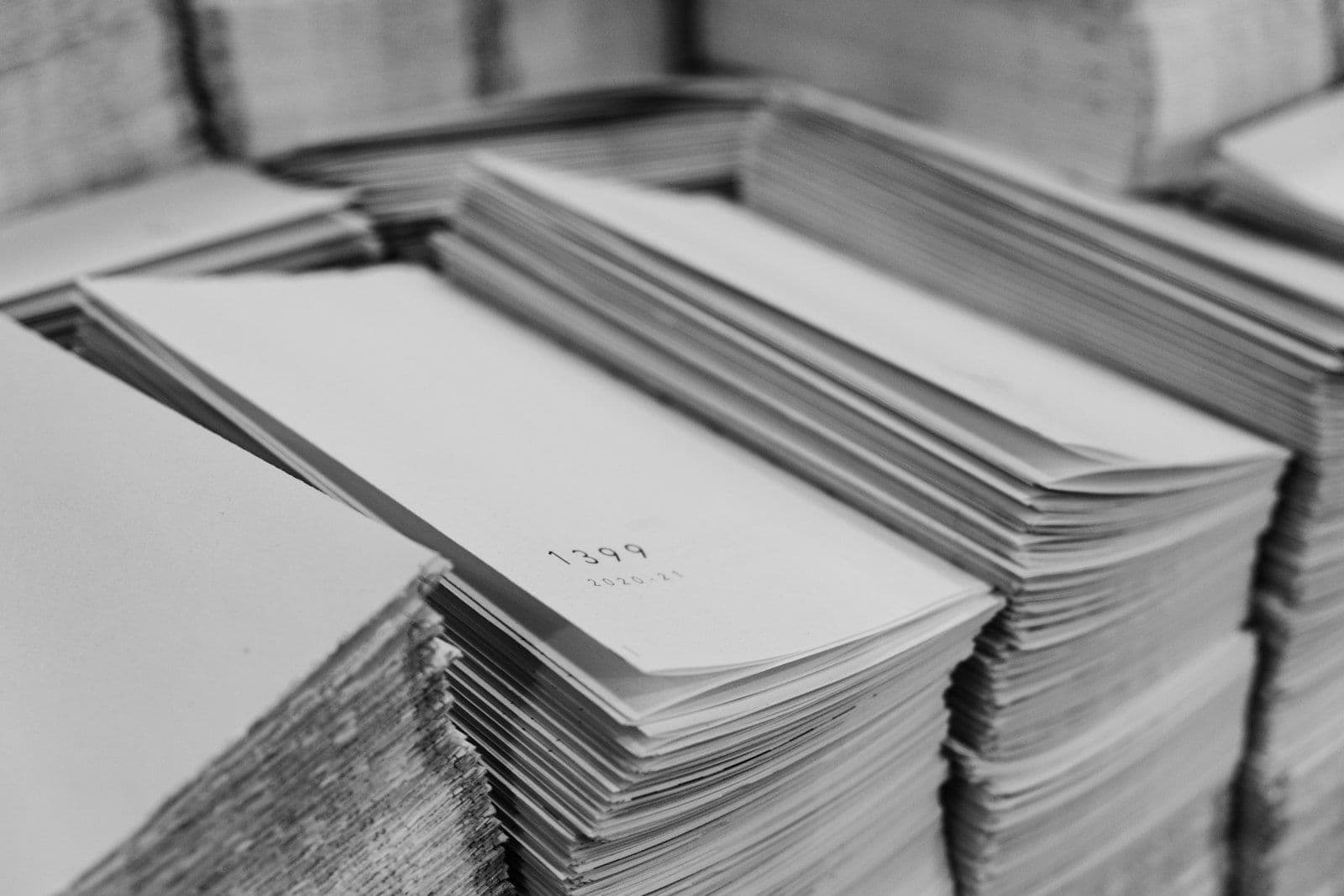 A stack of papers sitting on top of a table, illustrating paid vs Unpaid Collections.