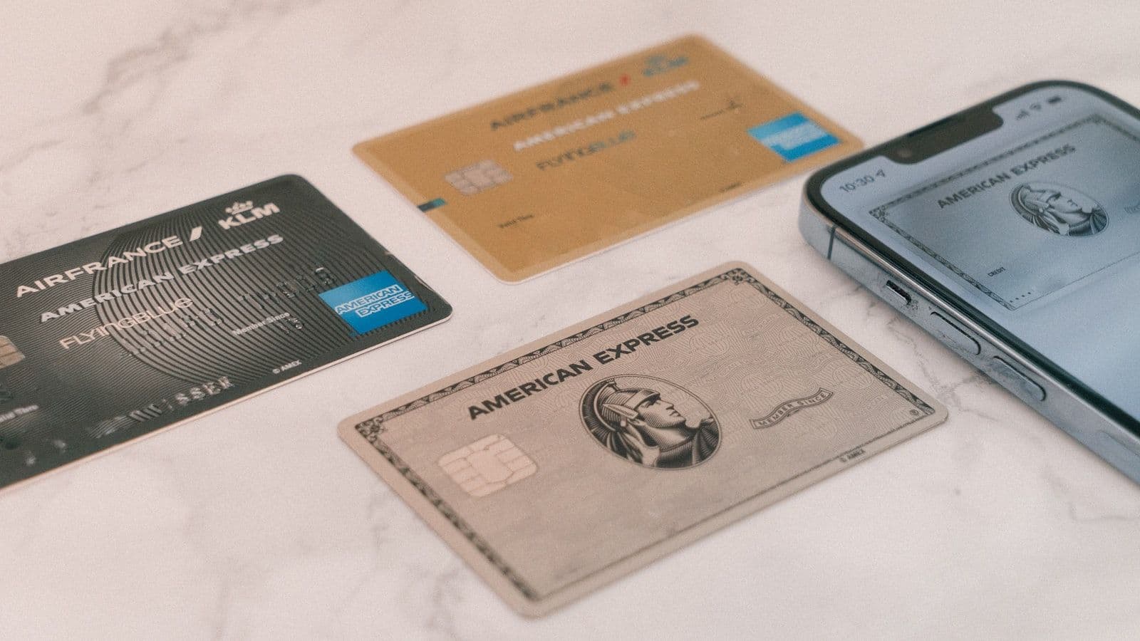 Varias tarjetas de crédito junto a un teléfono, ilustrando cómo ser usuario autorizado construye crédito.