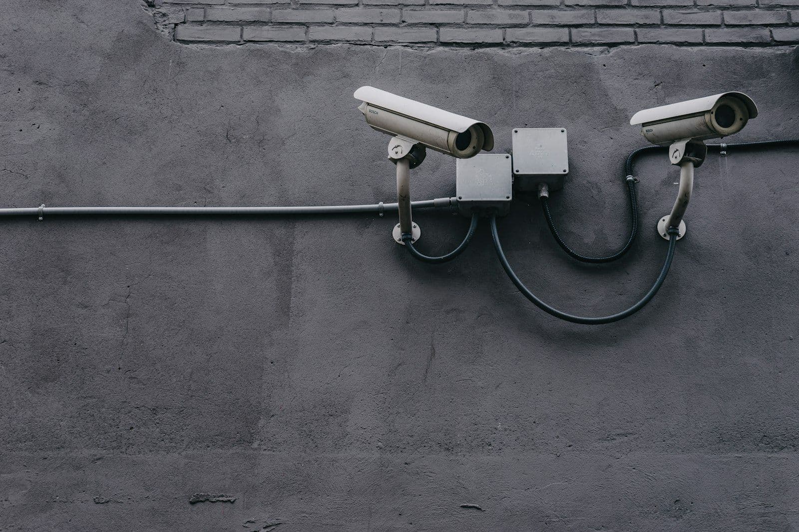 Security camera on a wall, illustrating what credit monitoring watches and what it cannot prevent.