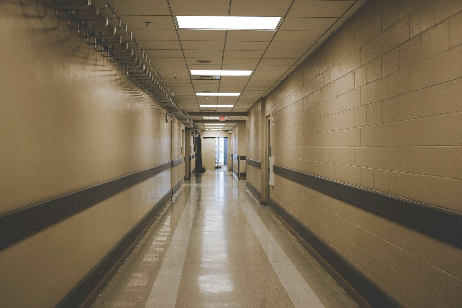 An empty hospital corridor under fluorescent lights