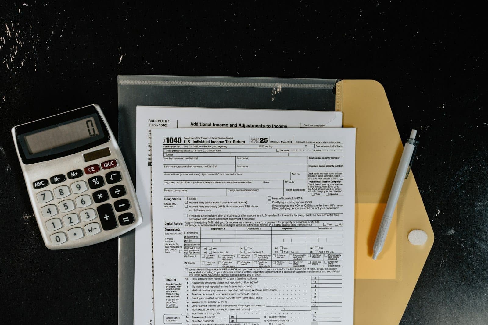 A calculator on top of printed tax forms, illustrating taxes on settled or forgiven debt.