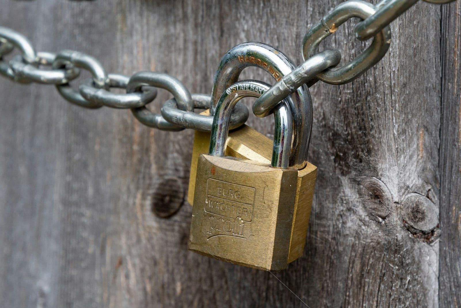 Brown padlock on brown wooden fence, illustrating credit Freeze vs Fraud Alert vs Credit Lock.