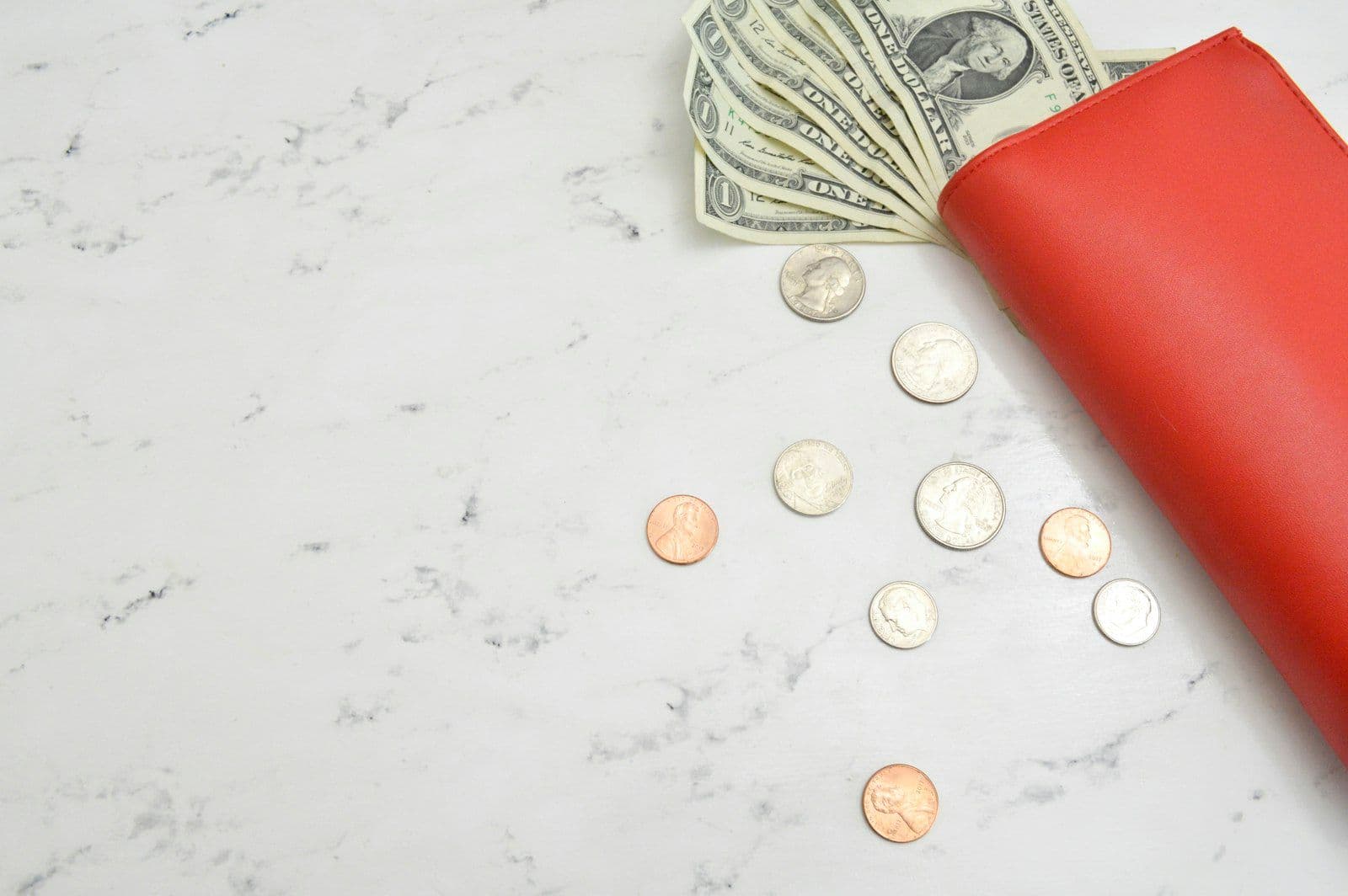Hands organizing cash and a notebook, illustrating how to get out of debt.