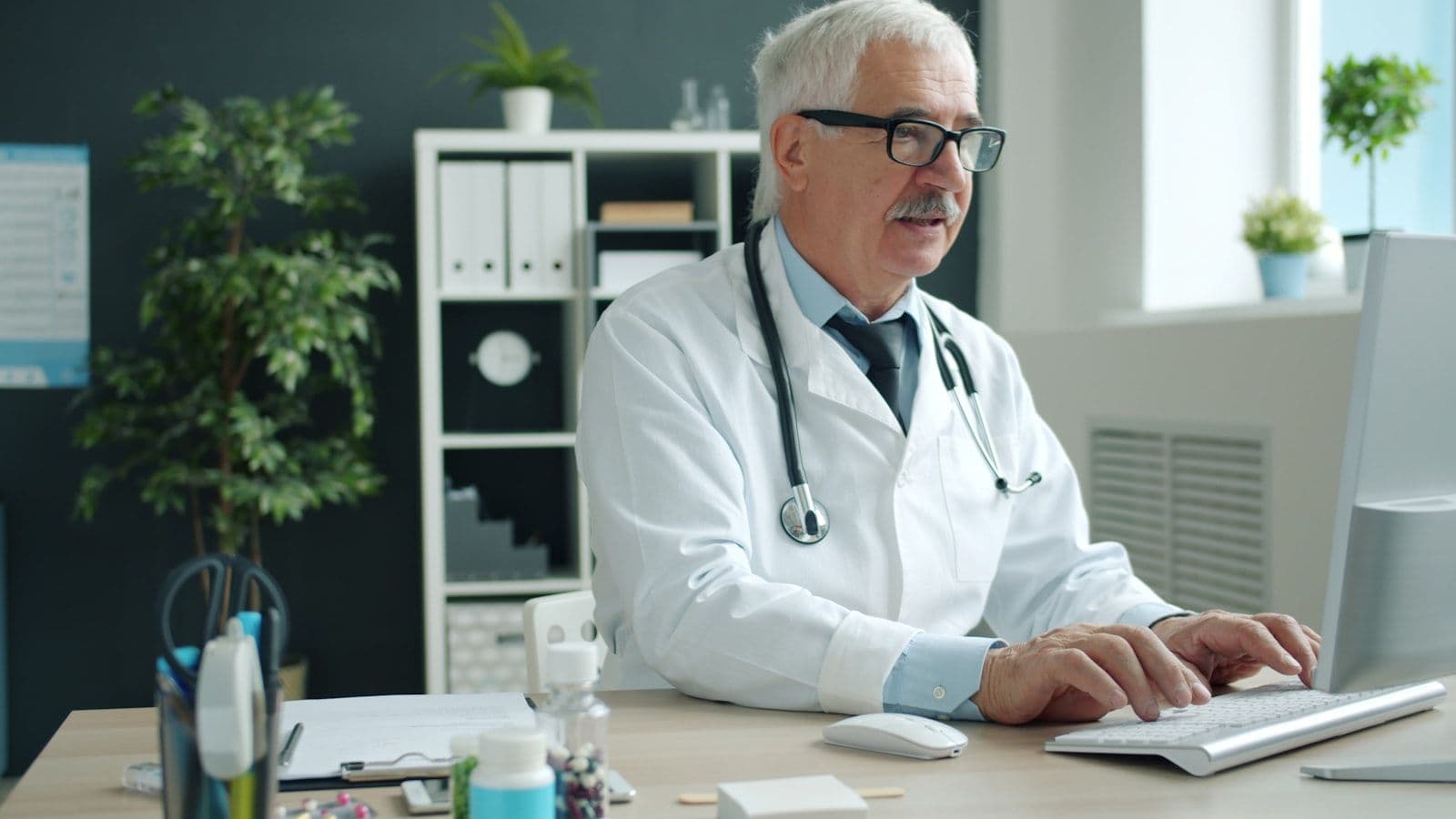 Doctor typing on computer in office, illustrating medical Debt Validation Rights Under the FDCPA.