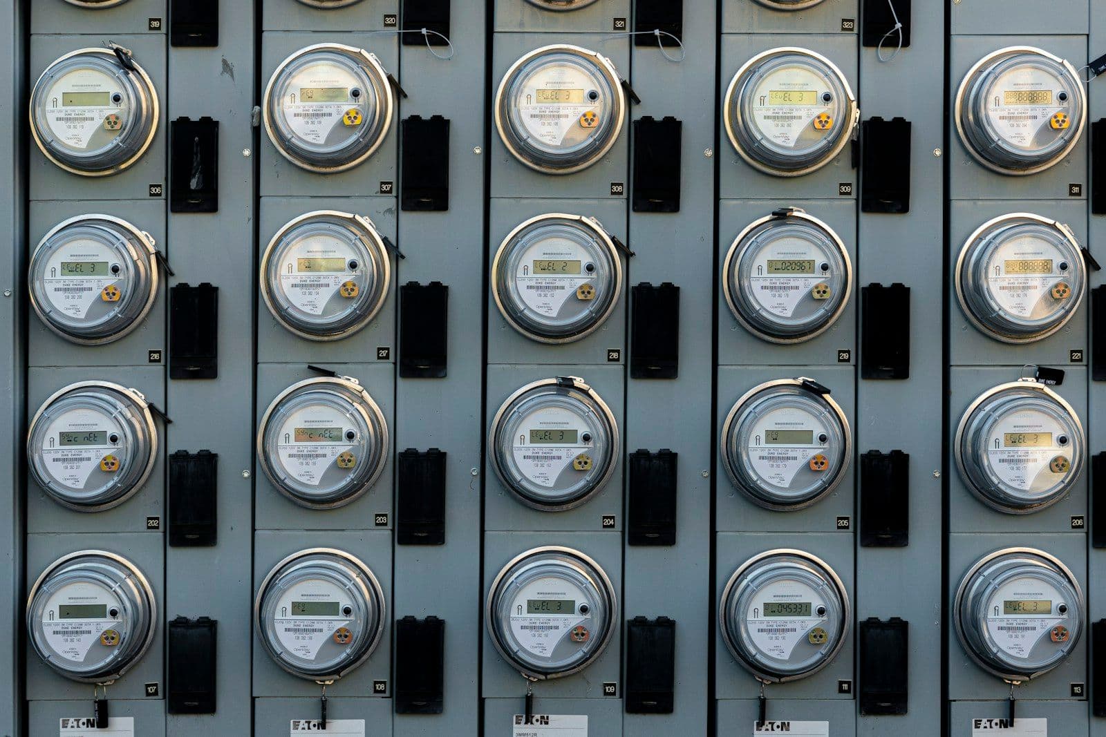 Row of stacked residential electric utility meters mounted on an exterior wall