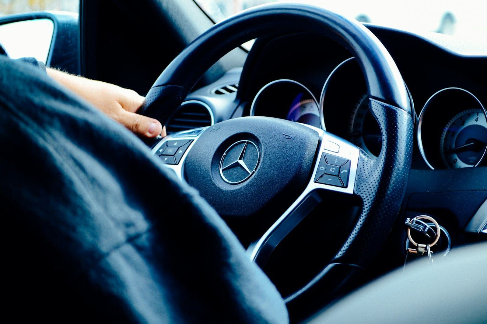 Black Mercedes-Benz vehicle steering wheel, illustrating e-OSCAR.
