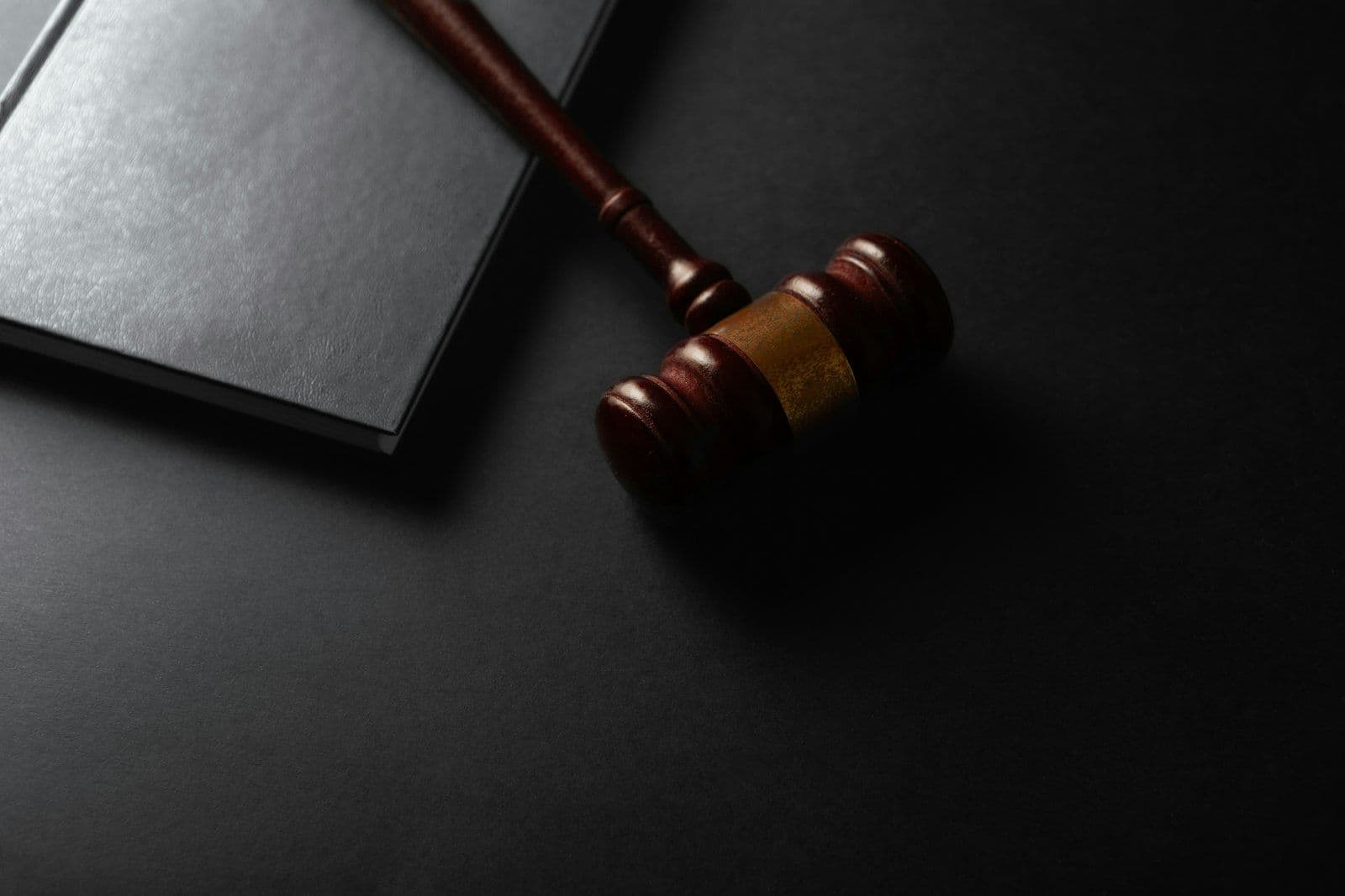 Judge gavel and law book on a black background, illustrating the FCRA rules for reinserted credit report items.