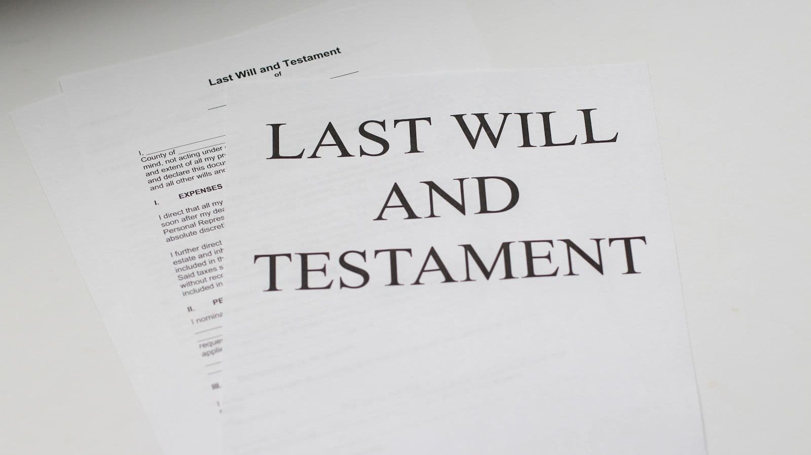 Estate documents on a desk, illustrating how debts are paid by the estate after a death.
