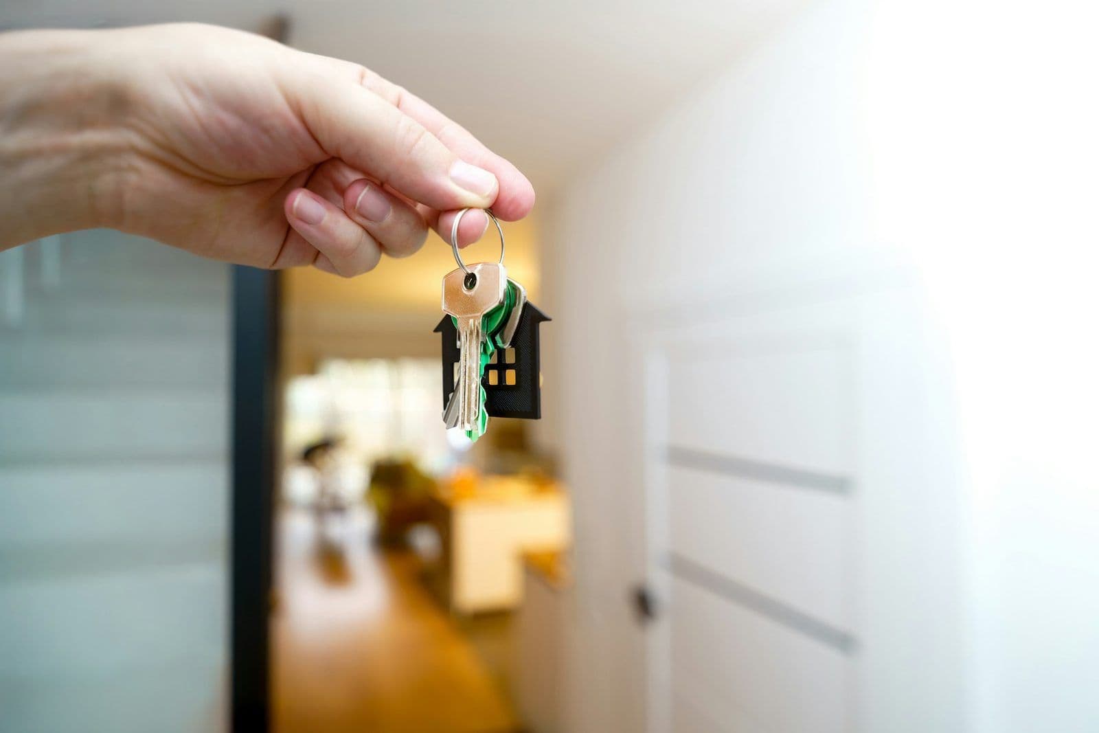 A hand holding house keys, illustrating buying a home after bankruptcy.
