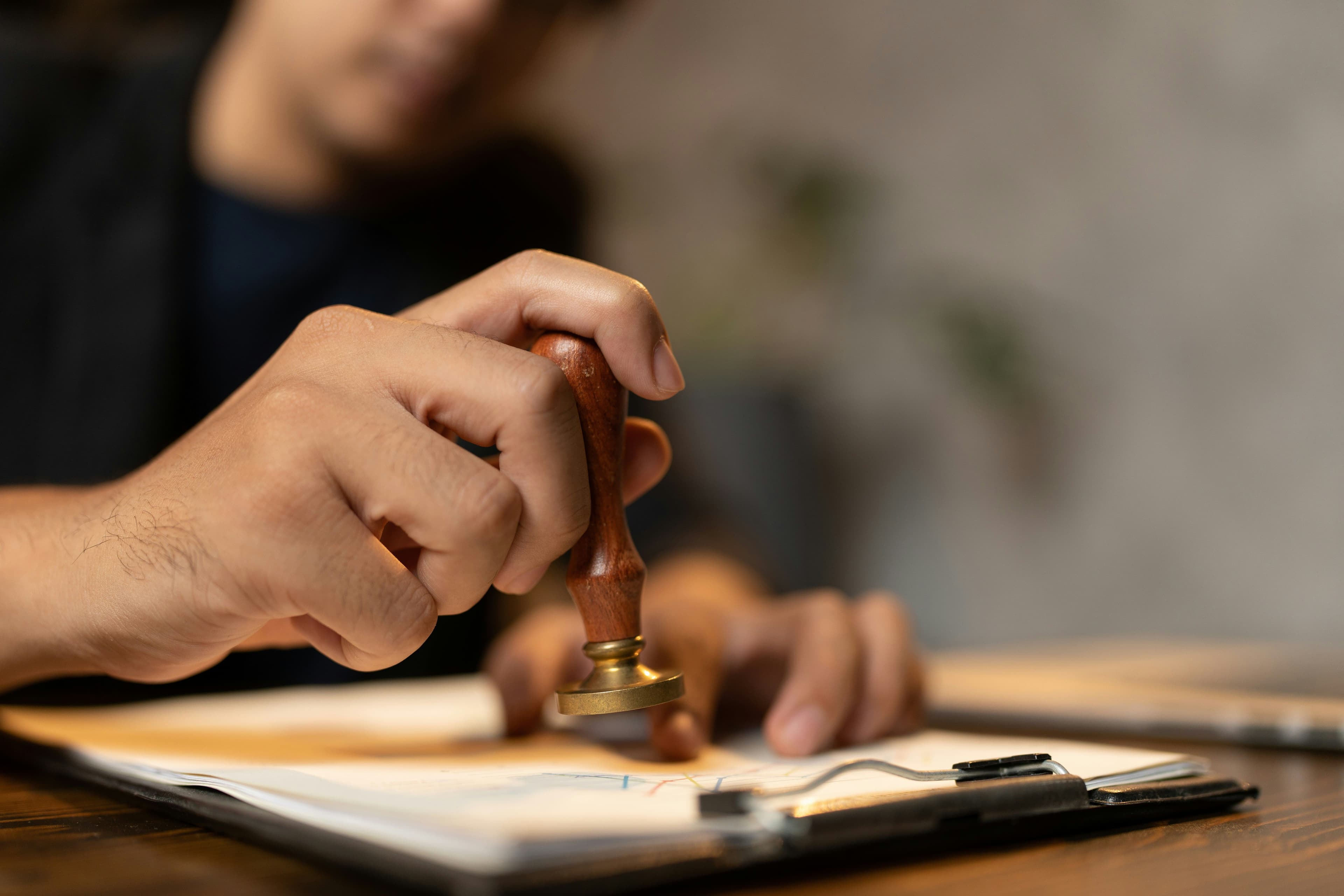 Hand pressing an official seal stamp onto a clipped document, illustrating the FCRA verification request process