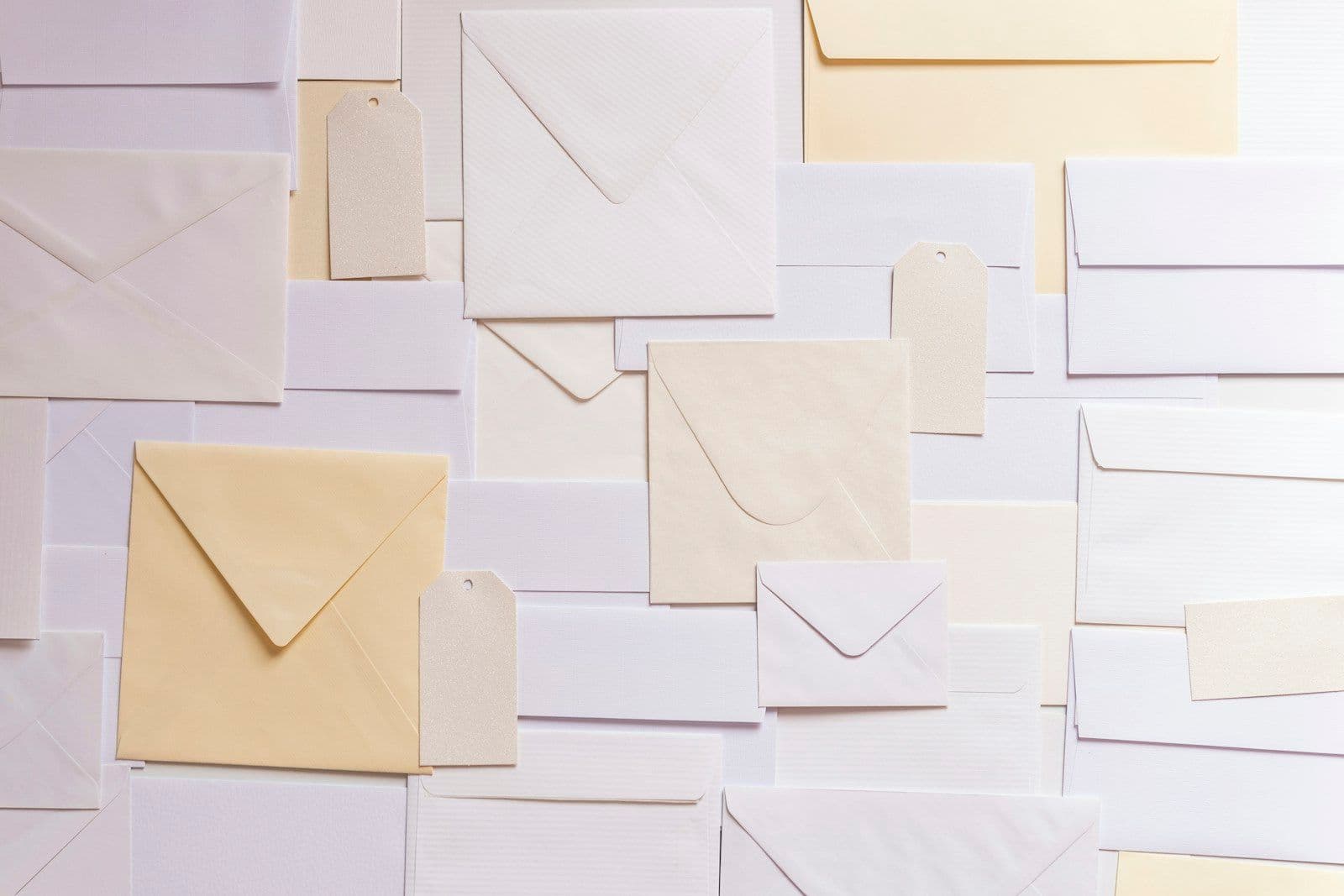 Neatly arranged stack of plain white and cream envelopes without visible text or markings