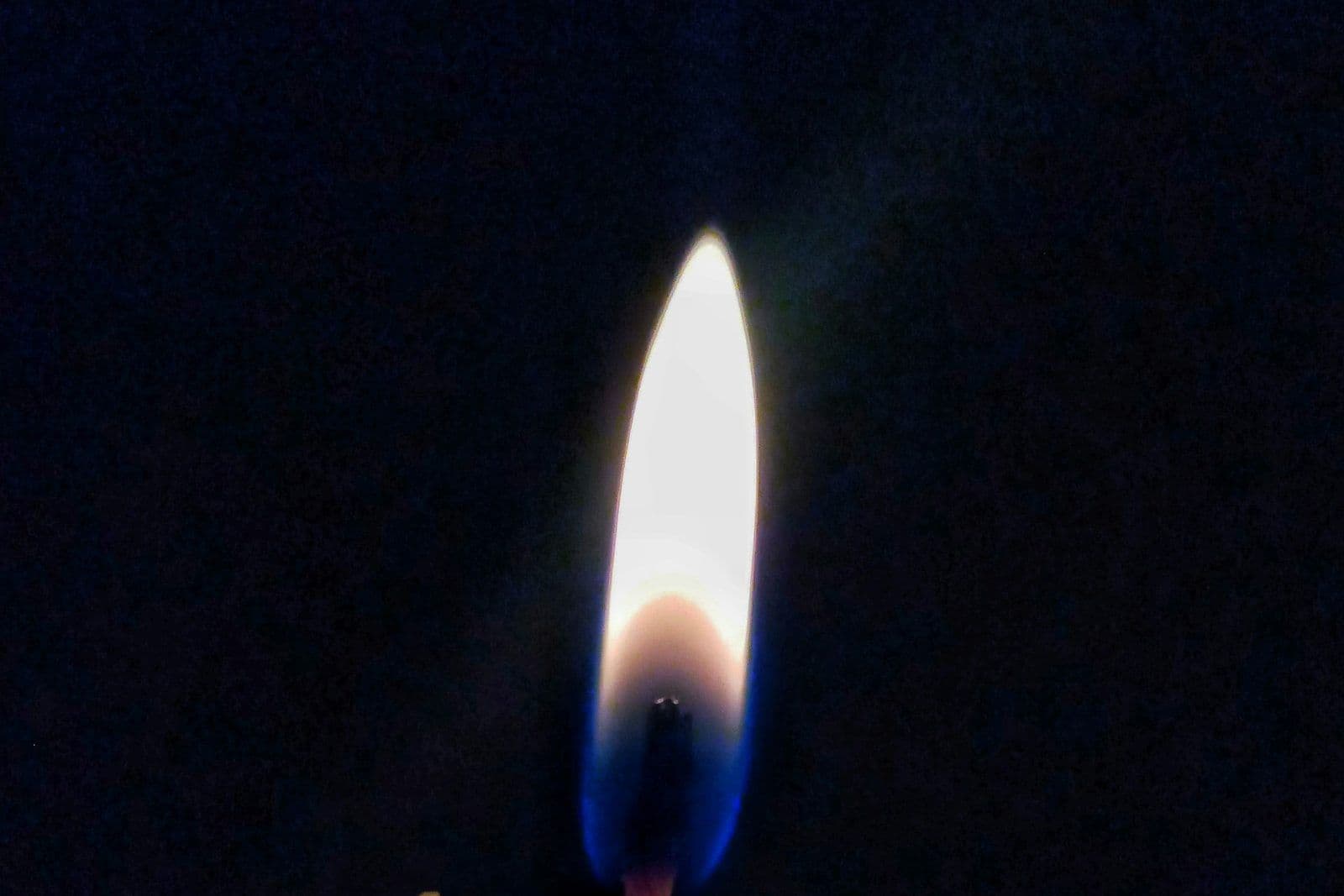 Una vela encendida en la oscuridad, ilustrando qué pasa con las deudas de un familiar fallecido.