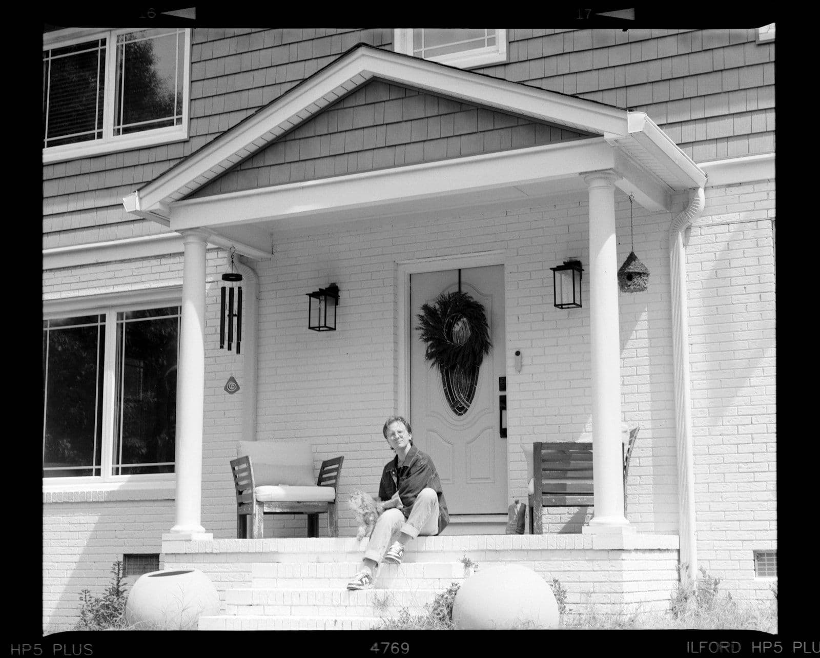 Person sitting on front porch steps of a house, illustrating $87,000 in Lost Money.
