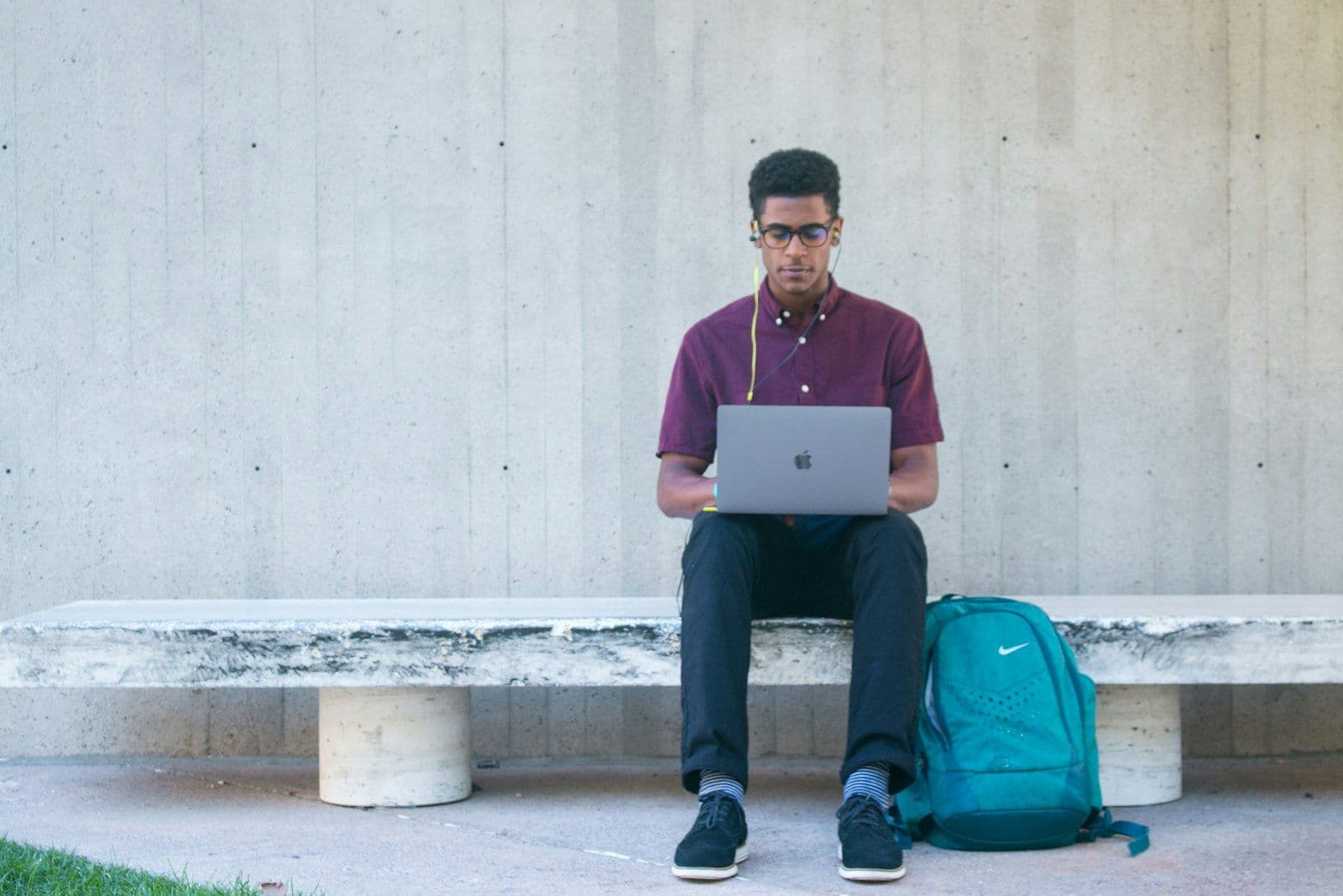 A college student studying on a laptop, illustrating how to build credit as a student.