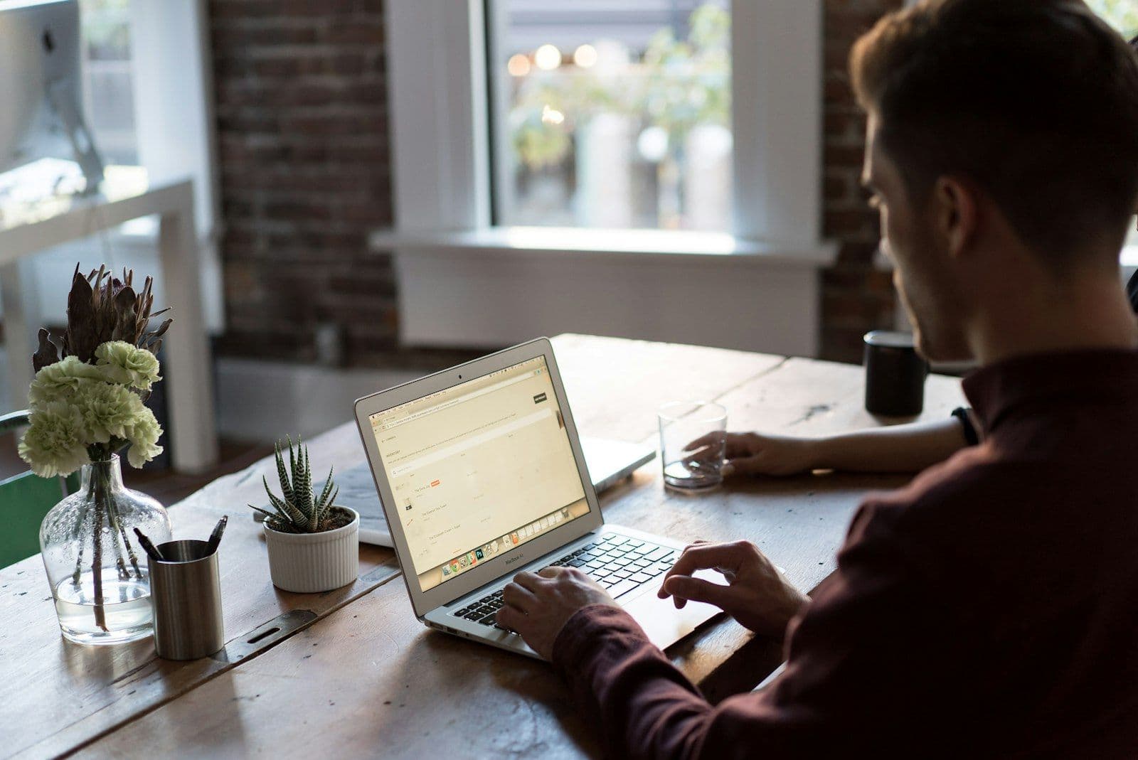 Man operating laptop on top of table, illustrating joint Accounts vs Authorized Users.