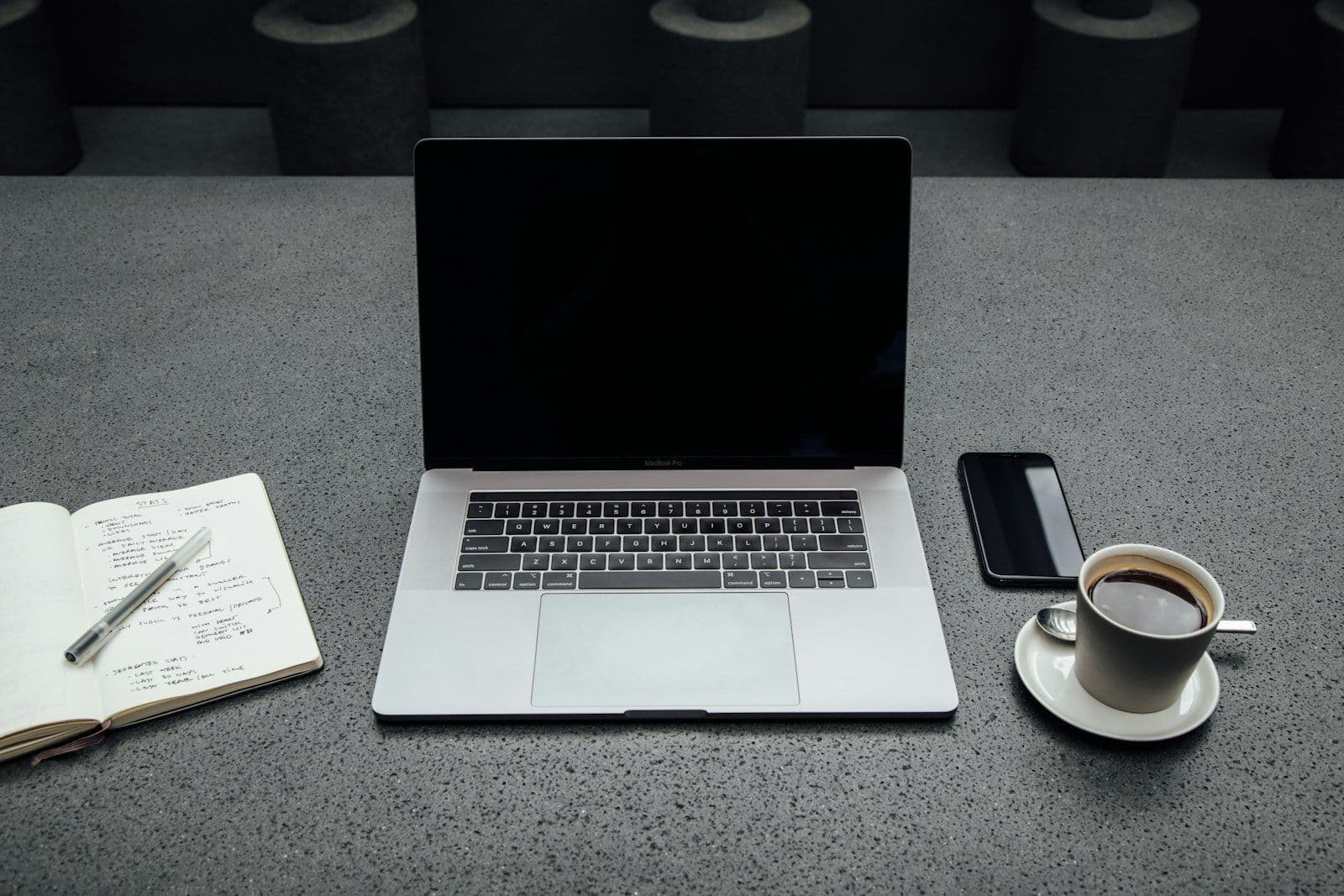 Turned-off MacBook Pro between cup of coffee, iPhone, notebook, and pen, illustrating mixed Credit Files.