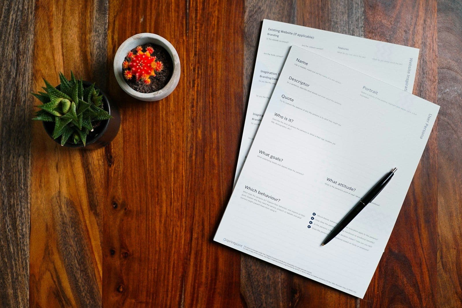 A wooden table topped with papers and a pen, illustrating how to Remove Late Payments From a Credit Report.